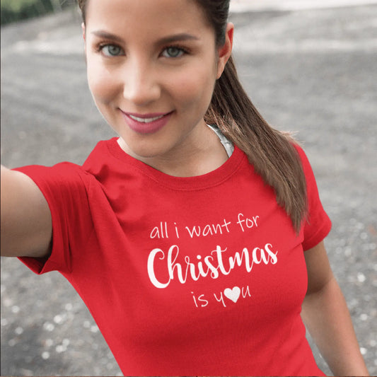 Holka v červeném vánočním tričku s ikonickým nápisem All I want for Christmas is You