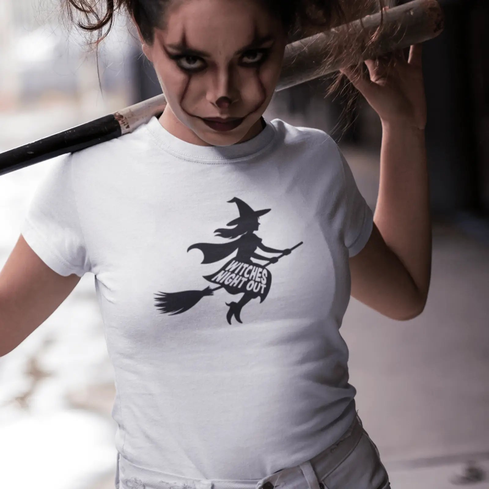 Holka v bílém Halloween tričku s čarodějnicí a nápisem Witches Night Out