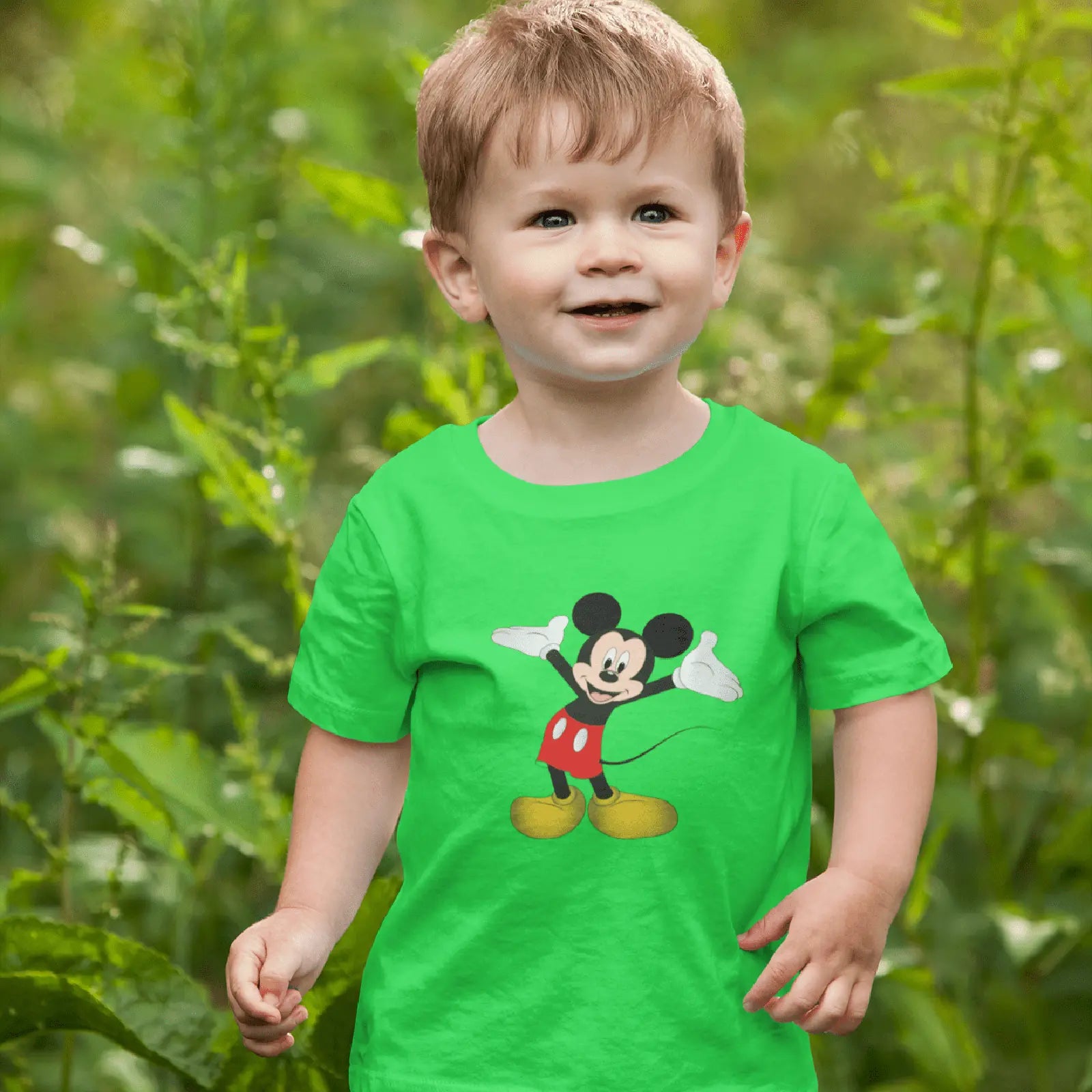 Malý kluk v dětském zeleném tričku Mickey Mouse
