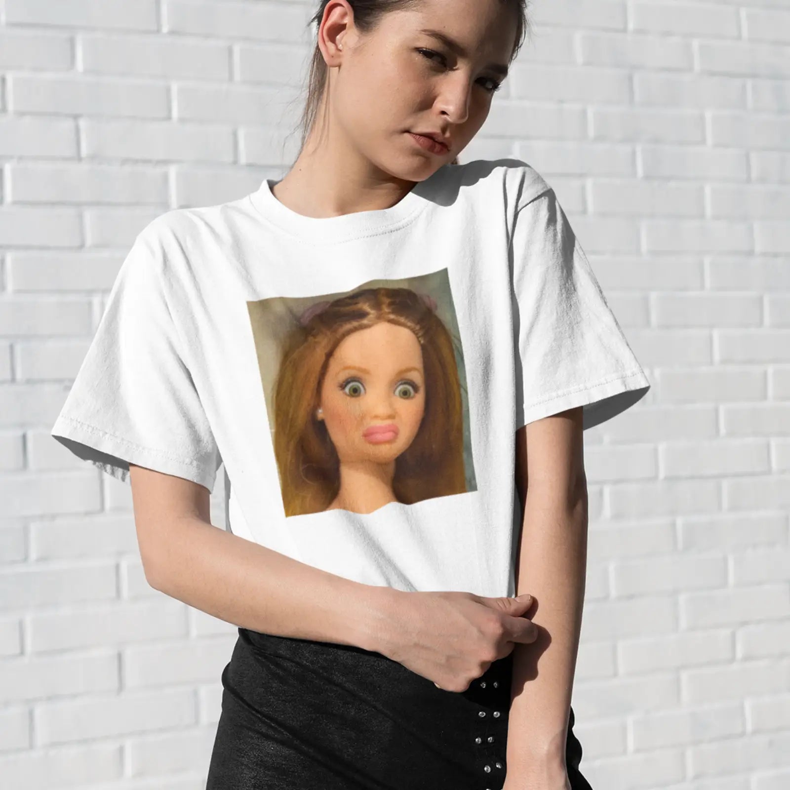 Holka v bílém tričku s fotkou funny doll