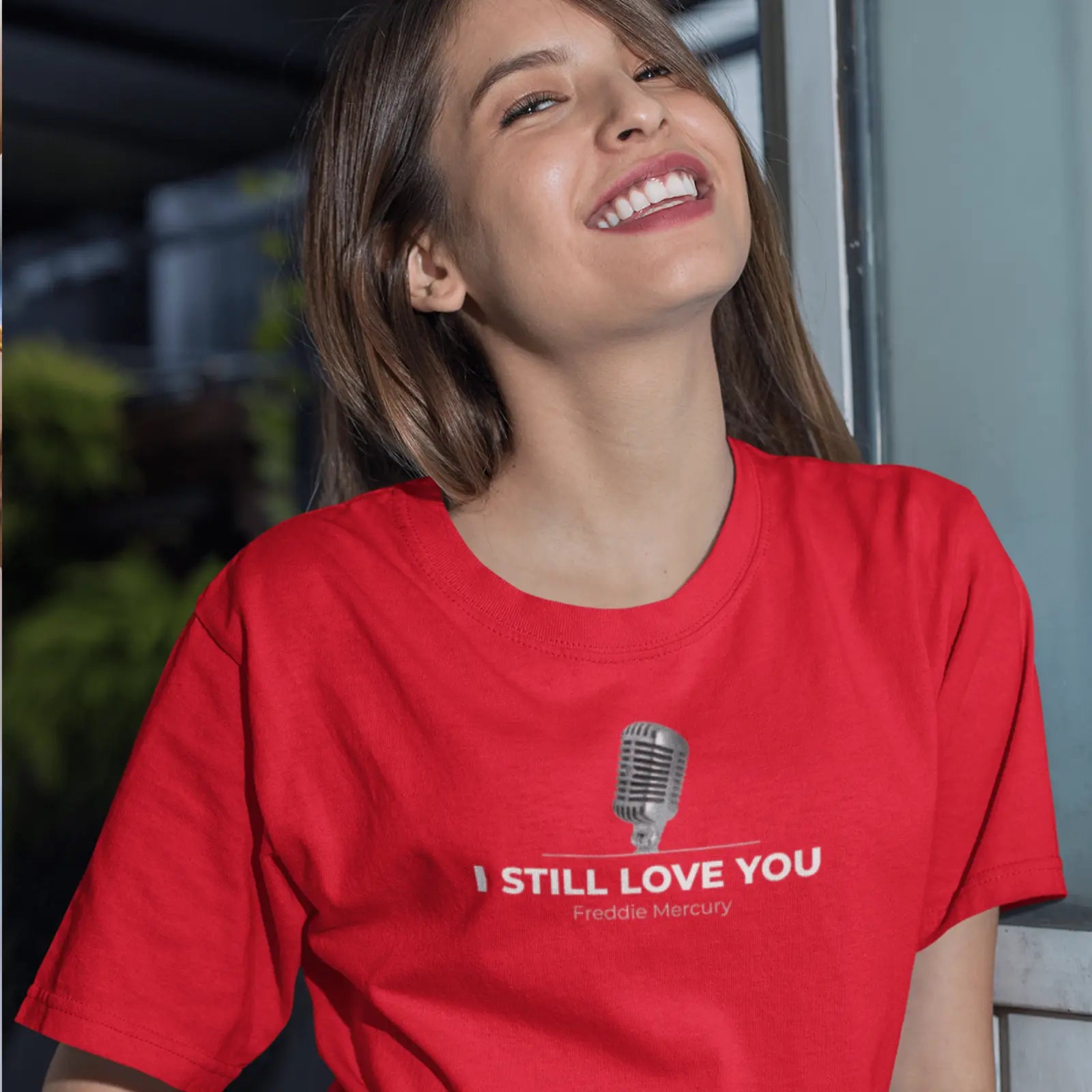 Holka v červeném tričku s mikrofonem a nápisem I still love you - Freddie Mercury
