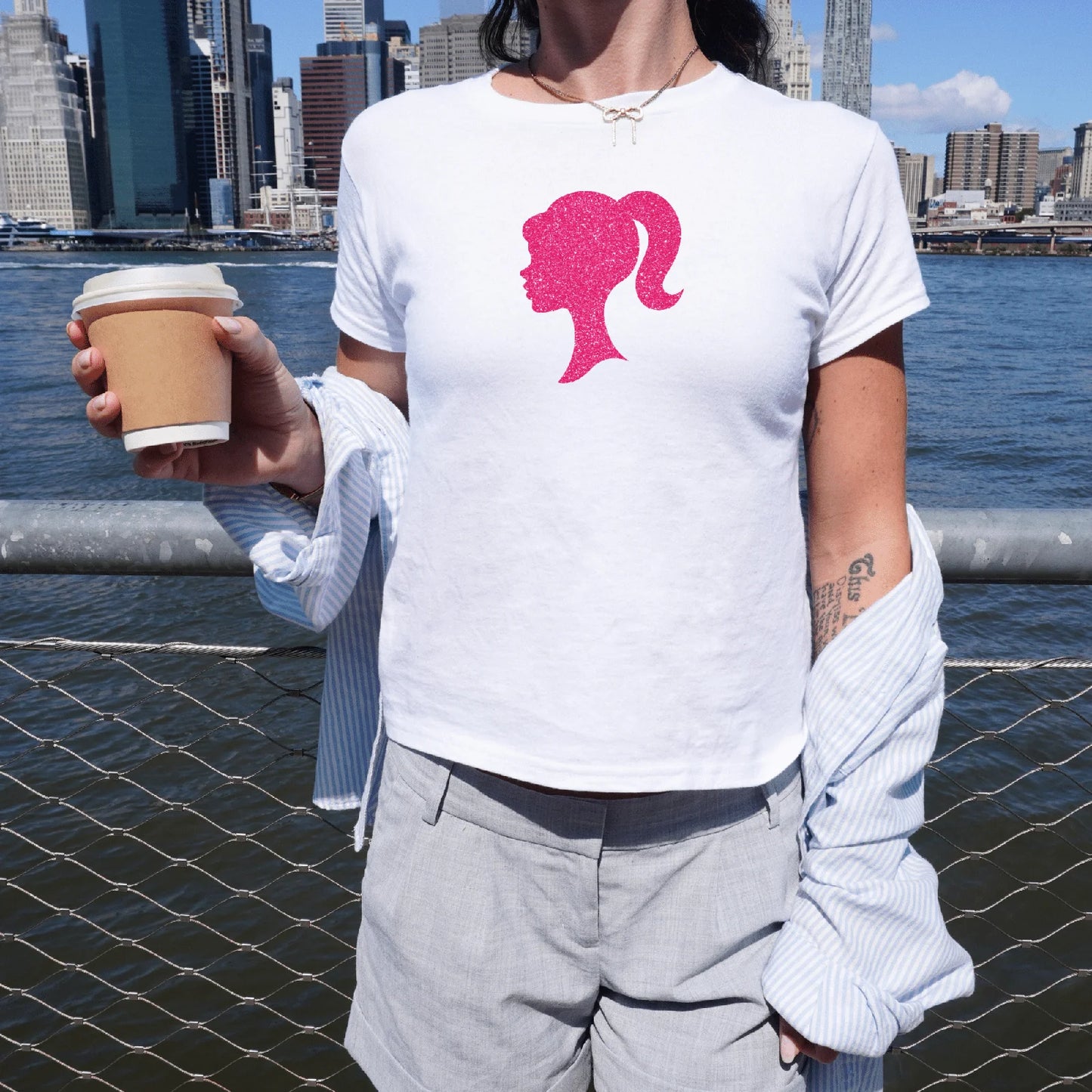 Holka v bílém baby tee s barbie siluetou