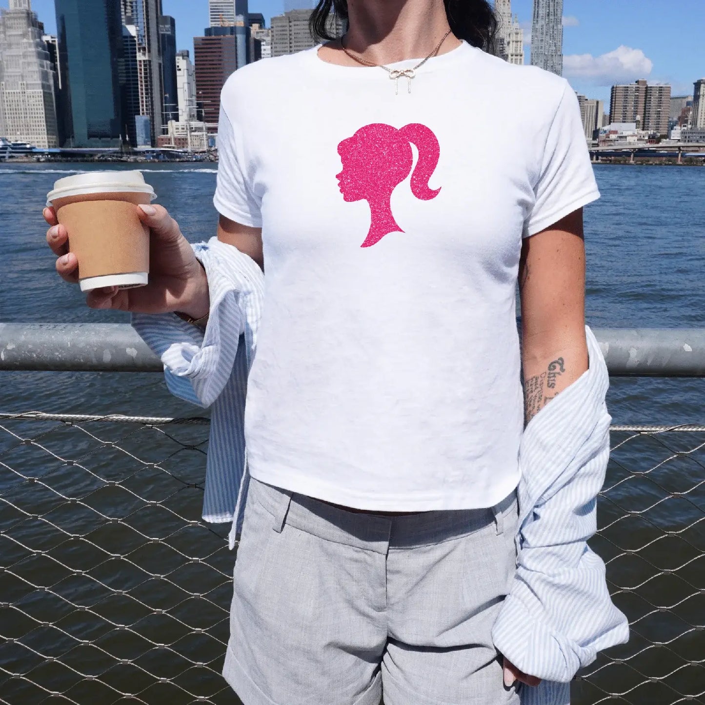 Holka v bílém baby tee s barbie siluetou