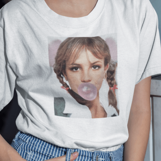 Holka v bílém tričku pro fanoušky Britney Spears s bublinou ze žvýkačky