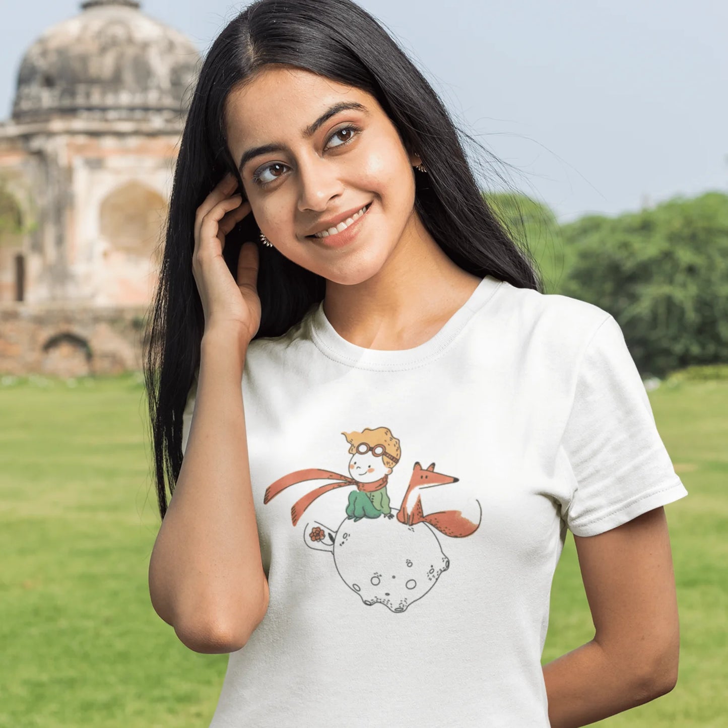 Holka v bílém tričku s kresbou Malého Prince s liškou a růží