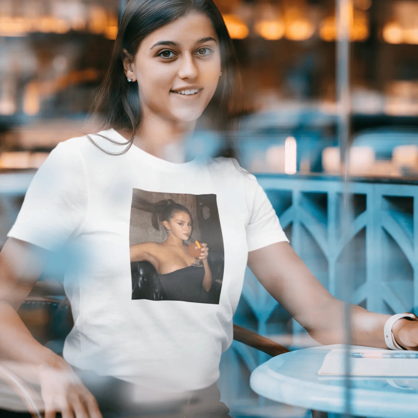 Holka v bílém tričku se Selenou Gomez s drinkem v ruce