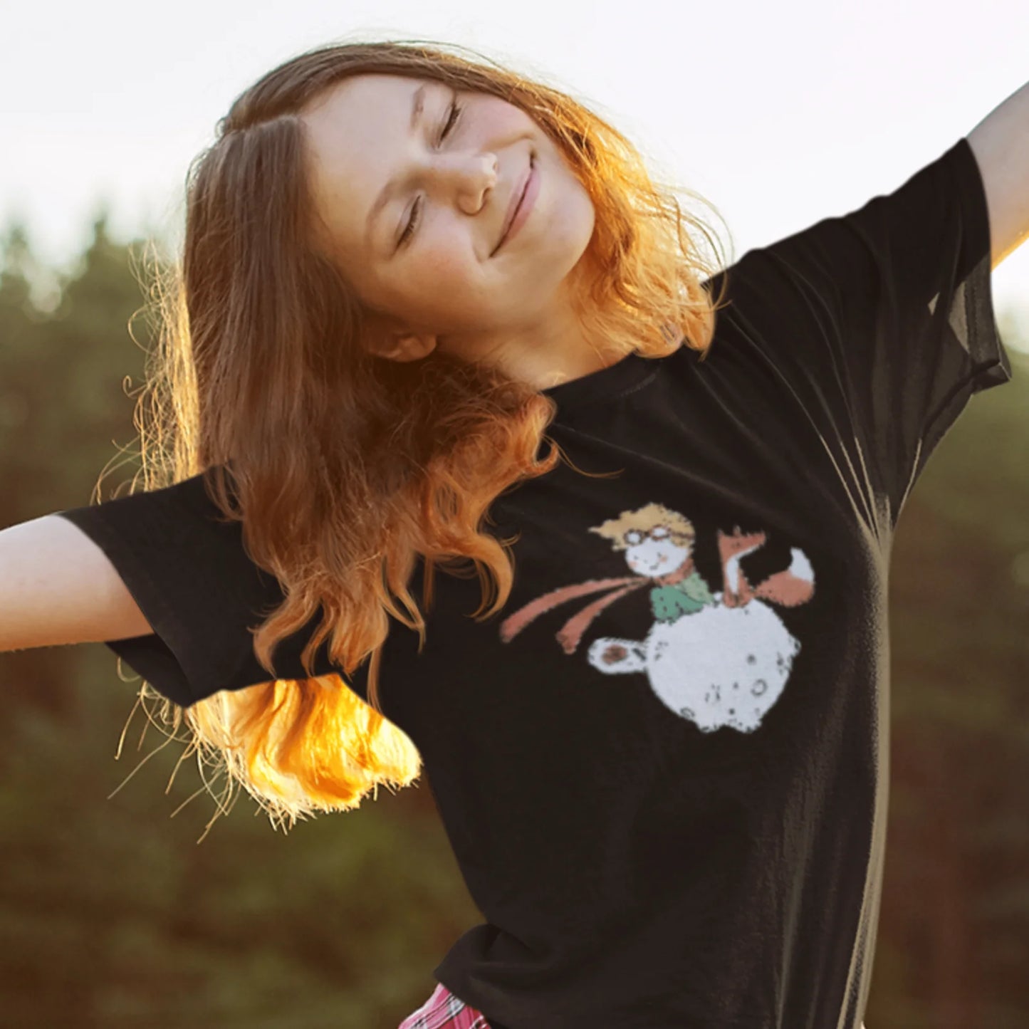 Holka v černém tričku s kresbou Malého Prince s liškou a růží