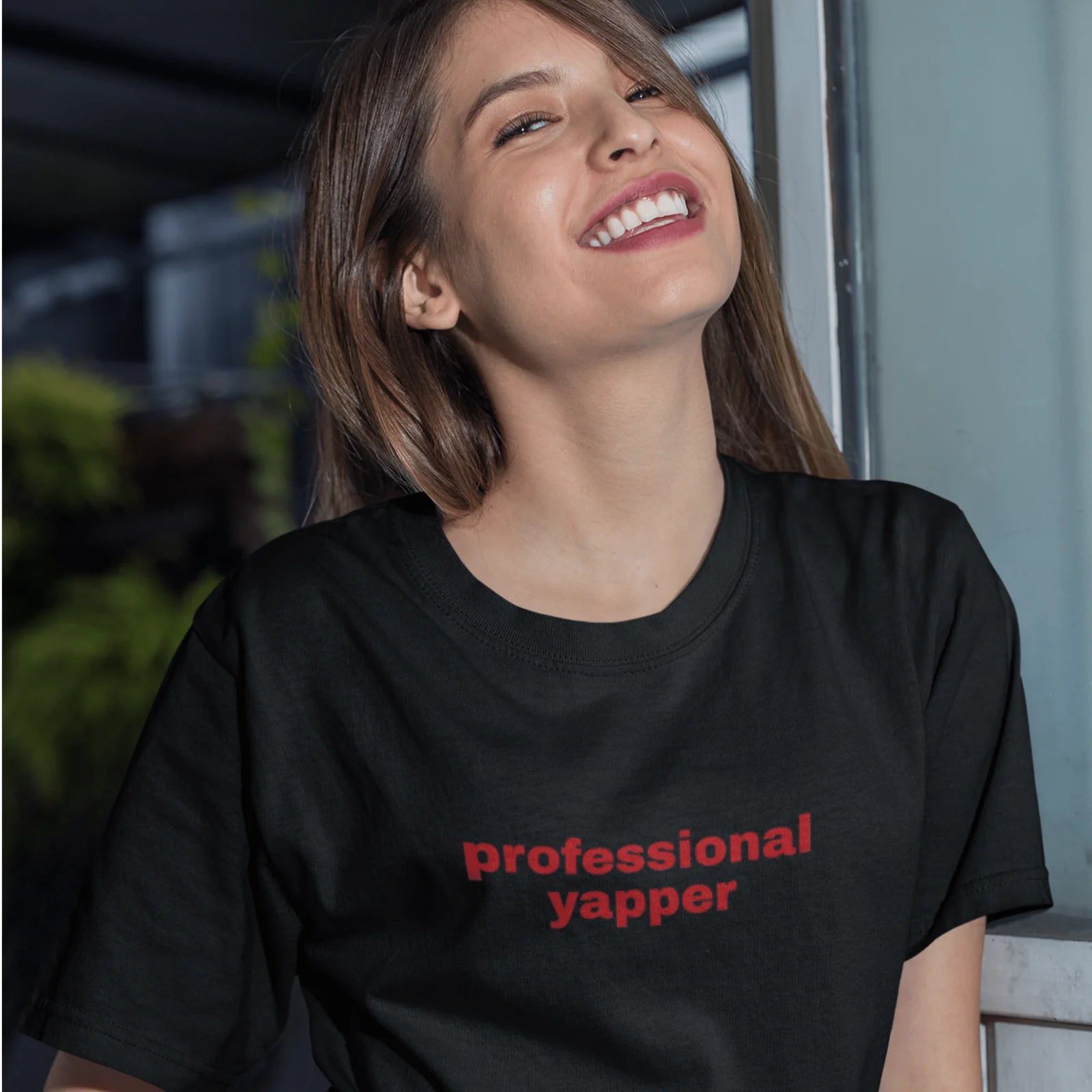 Holka v černém tričku s červeným nápisem professional yapper