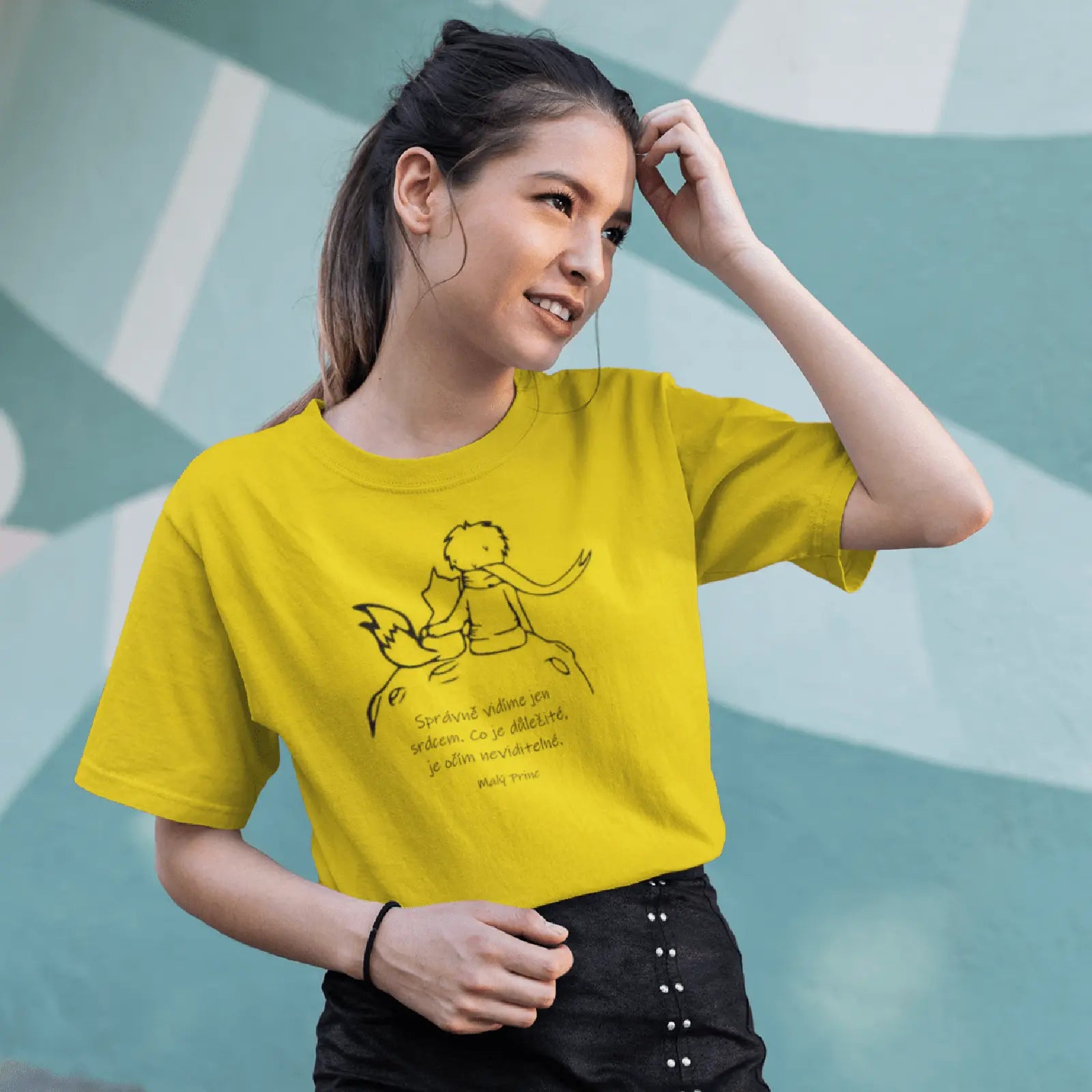 Holka ve žlutém tričku s Malým Princem s citátem