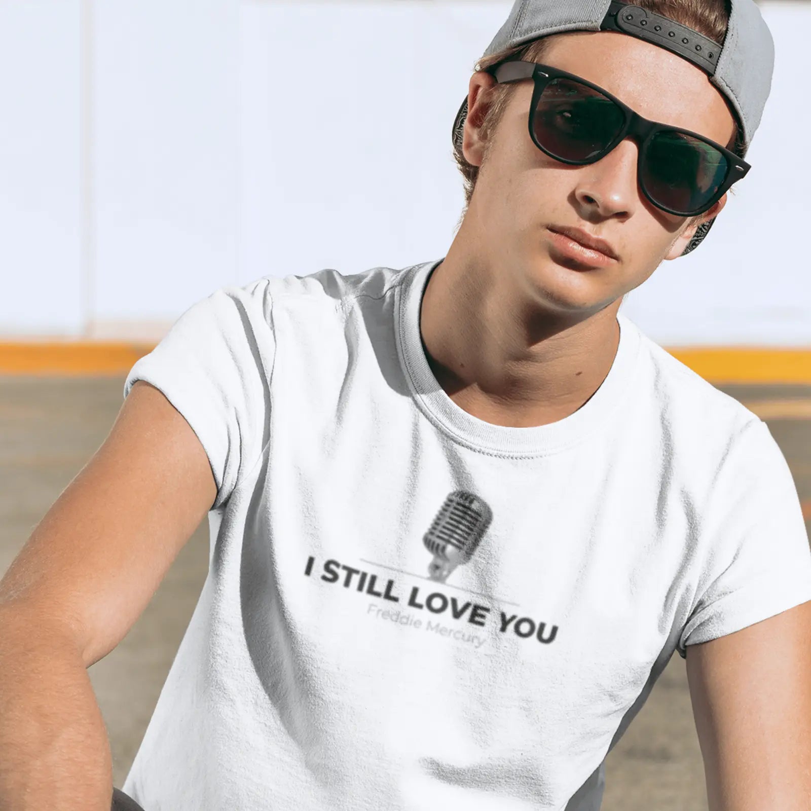 Kluk v bílém tričku s mikrofonem a nápisem I still love you - Freddie Mercury