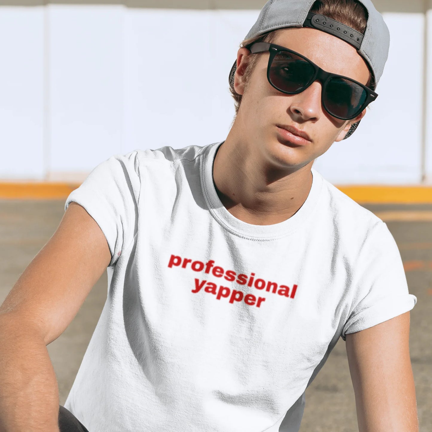 Kluk v bílém tričku s červeným nápisem professional yapper