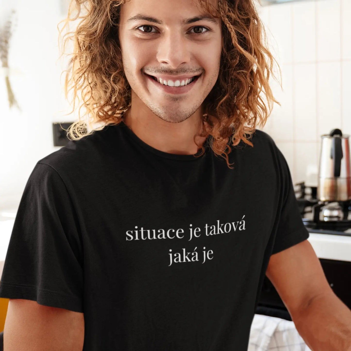 Muž v černém tričku s nápisem Situace je taková jaká je