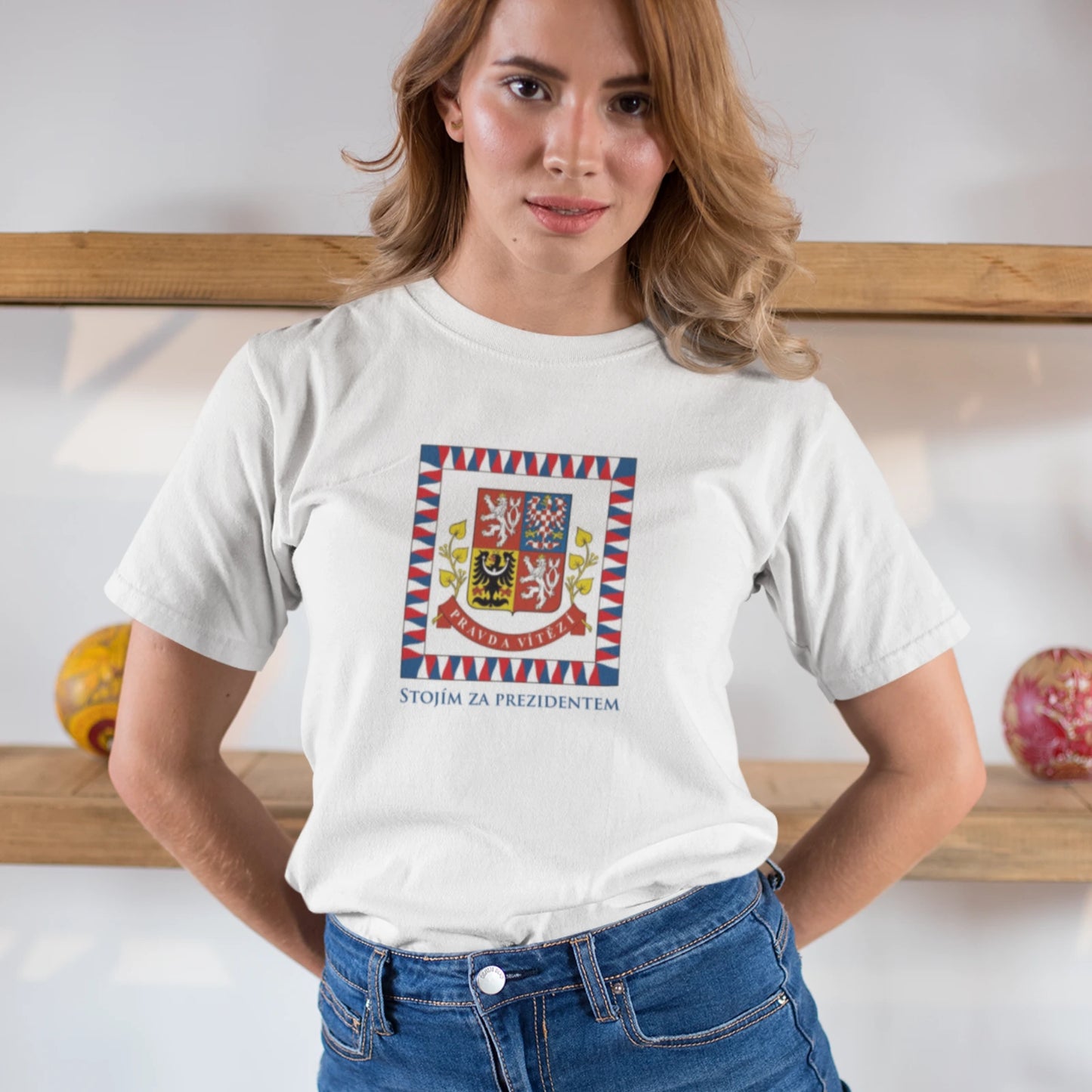 Žena v bílém triku s prezidentskou standardou a nápisem Stojím za prezidentem  