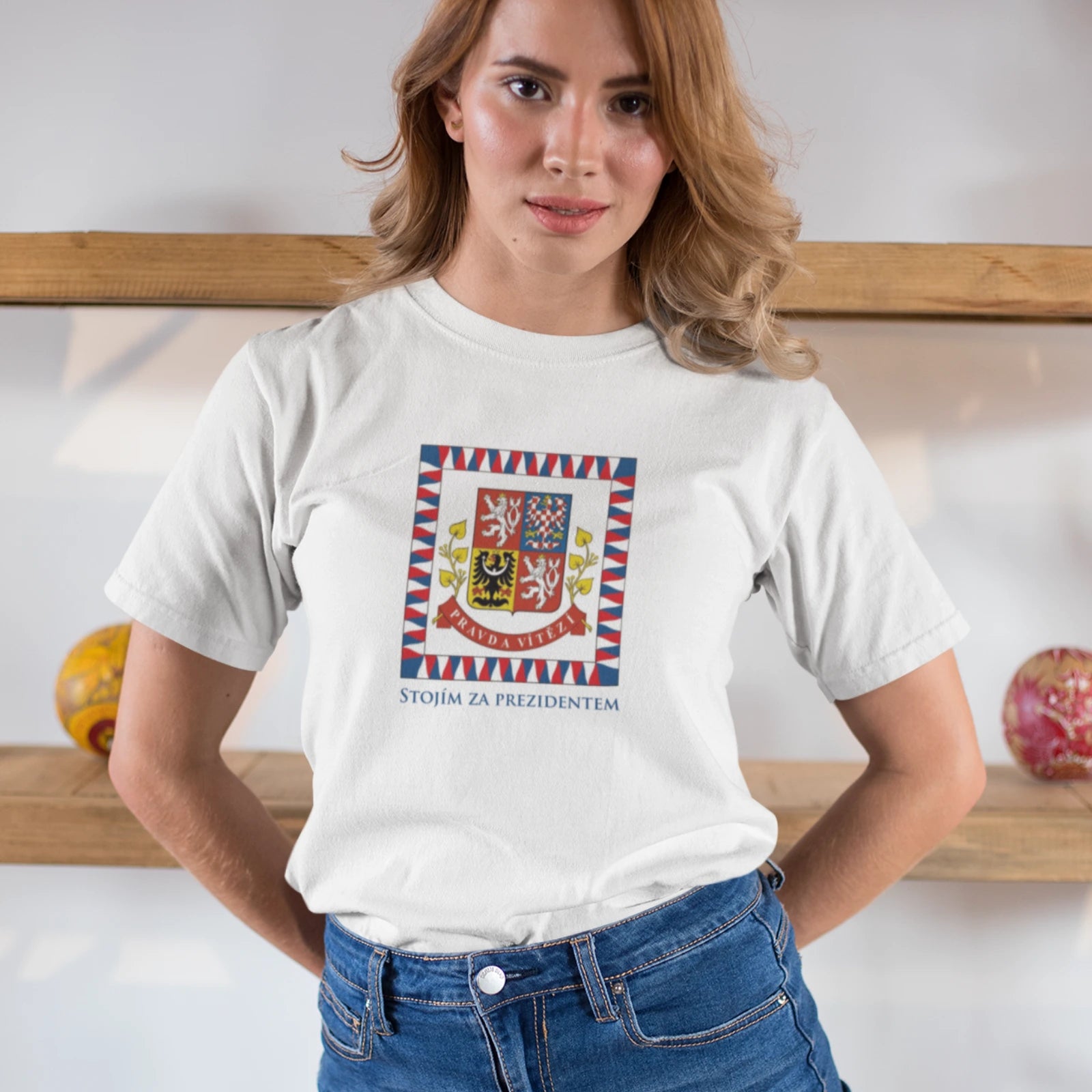Žena v bílém triku s prezidentskou standardou a nápisem Stojím za prezidentem  