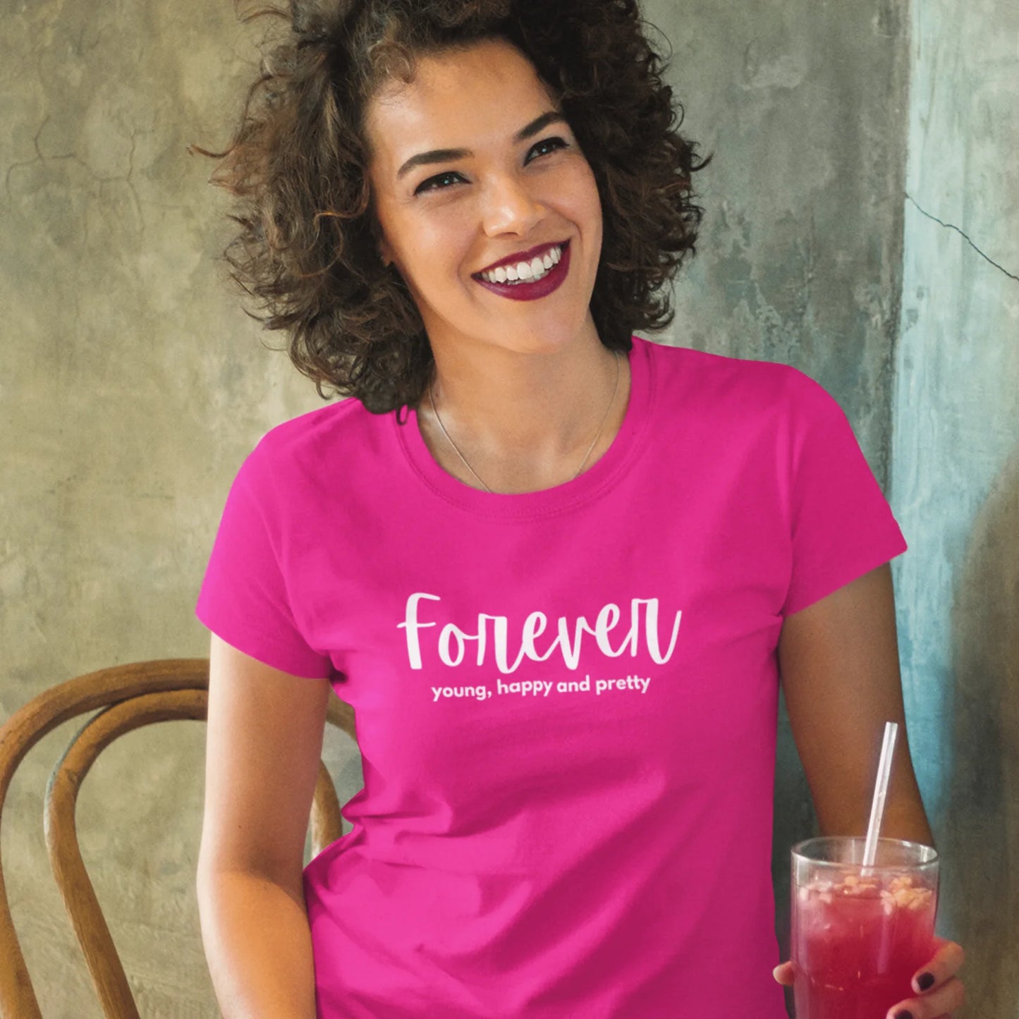 Žena v růžovém tričku s nápisem Forever Young, Happy & Pretty – věčně mladá a krásná!